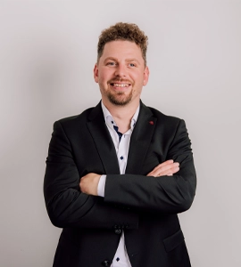 Lars Hartung – Geschäftsführer Institut für beruflichen Erfolg, Portrait mit verschränkten Armen