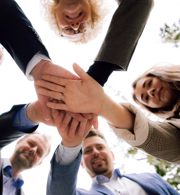 Das Team Institut für beruflichen Erfolg – gemeinsamer Handschlag als Symbol für Zusammenarbeit und Vertrauen